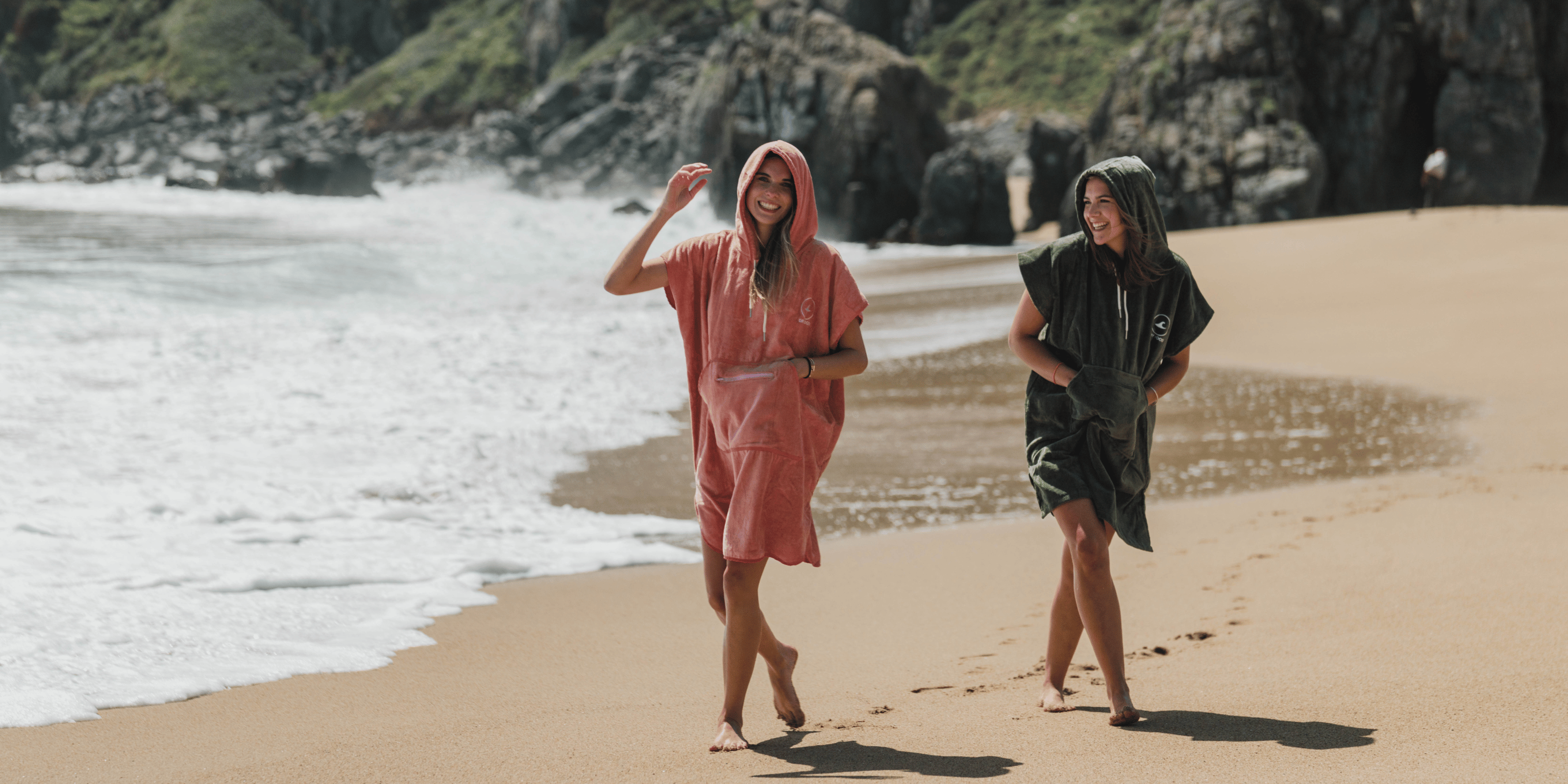 Personas usando poncho de toalla en la playa